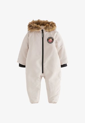Tuta imbottita color beige chiaro con cappuccio in pelliccia sintetica, chiusura con zip, polsini a costine e toppa con logo circolare sul petto.
