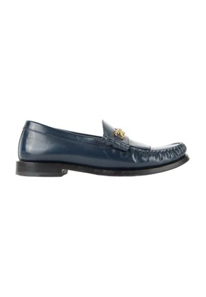Mocassin en cuir bleu foncé avec un petit talon et un détail décoratif doré à l'avant, présenté de profil sur fond blanc.