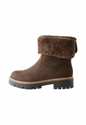 Braune Wildleder-Ankle Boots mit umklappbarem, gefüttertem Schaft, flacher schwarzer Gummisohle und kontrastierenden Nähten entlang der Kante.