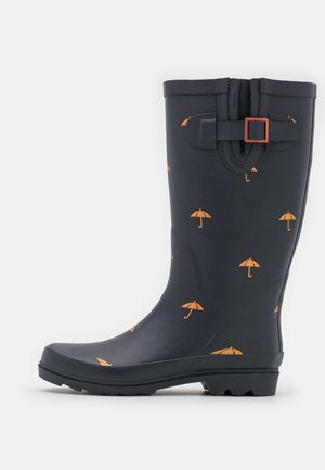Botte de pluie bleu marine avec motif parapluie orange, sangle réglable et boucle au niveau du mollet, et semelle texturée pour une meilleure adhérence.