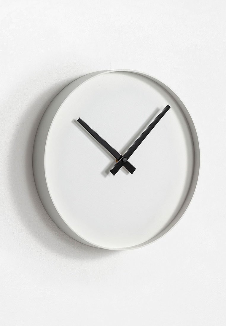 Ronde wandklok met een slanke grijze rand, white wijzerplaat en contrasterende zwarte wijzers, met een minimalistisch ontwerp zonder cijfers of versieringen.