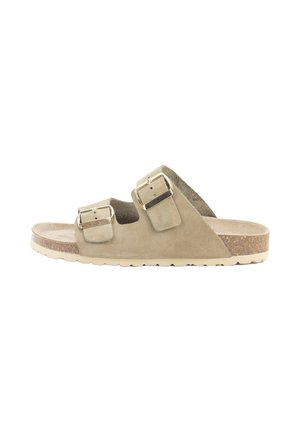 Sandalia de ante beige deslizante con dos hebillas ajustables en tono dorado, plantilla de corcho y suela de goma texturizada, con un diseño de perfil bajo.