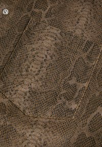 Brūna auduma ar čūskas rakstu un teksturētu virsmu. Ir kabatas detaļa un metāla snap aizdare. Krāsas saplūst brūnās un pelēkās niansēs.