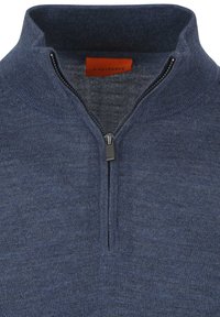 Marineblauwe gebreide sweater met halve rits en een verhoogde kraag, met een zichtbare metalen rits trekker, waarop een oranje label aan de binnenkant van de kraag te zien is.