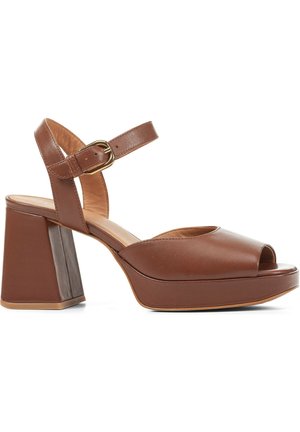 Sandales compensées en cuir marron avec bout ouvert, bride à la cheville et talon bloc épais. Texture lisse et détail d'accent en boucle dorée.