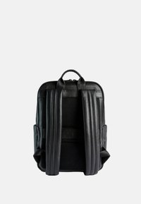 Zaino in pelle nera con spallacci imbottiti e regolabili e una maniglia superiore. Texture liscia con un design semplice e strutturato.