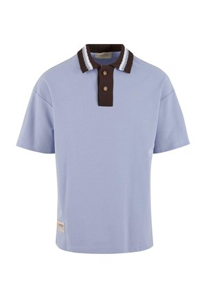 Világoskék pólóing, barna bordás gallérral, fehér csíkokkal, két barna gombbal, és egy kis logóval az elülső szegélyen.