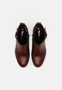 Hnědé kožené kotníkové boty s hladkým povrchem, kulatou špičkou a bokem se sponou. Velikost 37 je uvedena uvnitř.