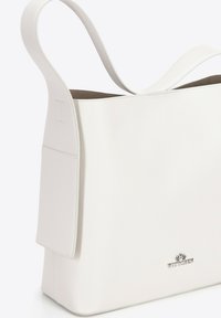 Bolso tote de cuero blanco con un exterior texturizado, dos largas correas para el hombro y un acento de logo plateado en la parte frontal. Presenta un diseño minimalista.
