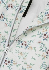 Stoff mit Blumenmuster auf weißem Hintergrund, der grüne Blätter und mehrfarbige Blumen zeigt. Detaillierter silberner Reißverschluss an der Seite.