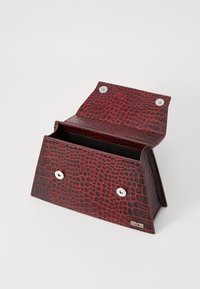 Portafoglio in ecopelle rossa con effetto coccodrillo, dalla forma triangolare, chiuso da due bottoni a pressione in metallo e dotato di un ampio interno.
