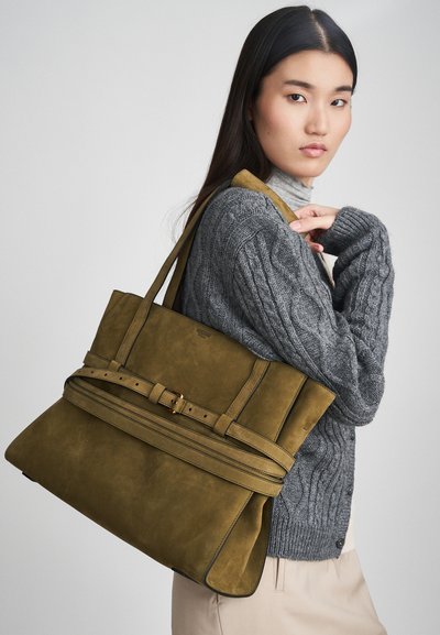 Πράσινη σουέντ τσάντα χειρός με δομημένο σχήμα, με φαρδύ λουρί και περιλαίμιο και χρυσές μεταλλικές λεπτομέρειες. Διακριτική υφή.