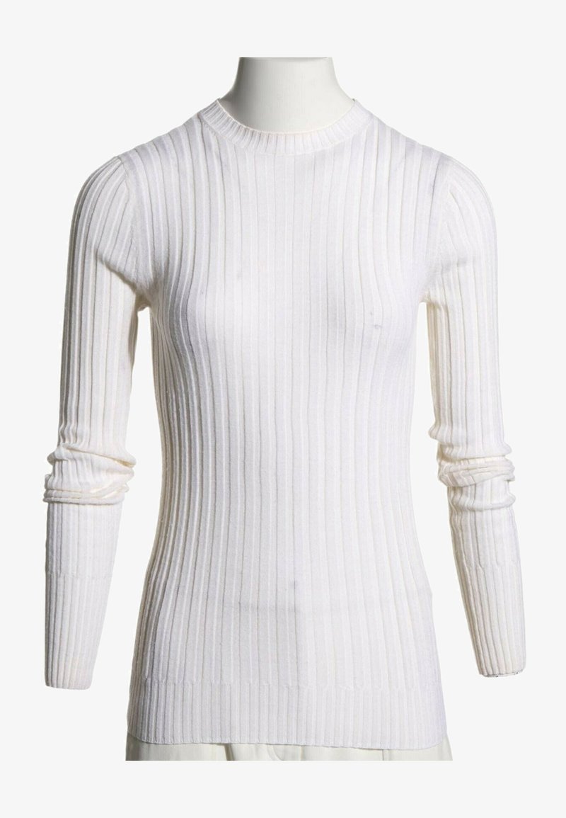 Pull blanc côtelé à manches longues avec col rond sur un mannequin, manches légèrement froncées au niveau des avant-bras, style ajusté.