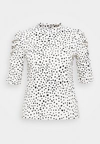 Top bianco a maniche corte con pois neri irregolari, caratterizzato da un collo alto e dettagli arricciati sulle spalle. Tessuto a trama liscia.