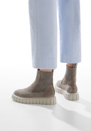 Gray suede ankle boots with a textured elastic side, chunky beige rubber sole, and a pull tab with black branding on the heel.