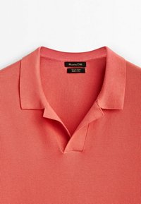 Polo manches courtes corail rose avec col ouvert et tissu texturé tissé, étiqueté "Massimo Dutti" en coton.