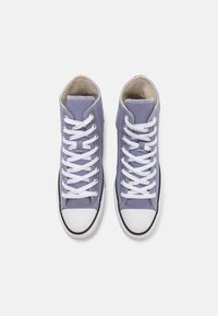 Höga sneakers i ljuslila kanvas med vita snören, gummitåhätta och svart sula. Med vitt stygn och en jämn yta.