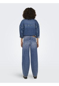 Skuren blå denimjacka med breda ärmar, i kombination med hög midja och löst sittande blå denimjeans. Strukturerad tyg, avslappnad design.