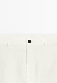 Witte linnenbroeken met een klassiek ontwerp, knoopsluiting en een vlakke voorkant met minimale stikseldetails.