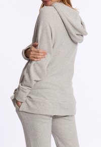 Grijze hoodie van zacht, textuurstof met een capuchon met trekkoord en zijzakken. Het ontwerp heeft een relaxte pasvorm en een buidelzak.