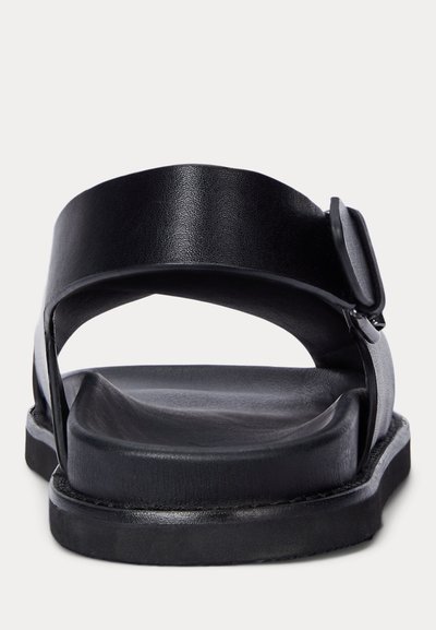 Fekete nyitott orrú szandál vastag párnázott talppal és széles, állítható hátpánttal, csattal záródik.