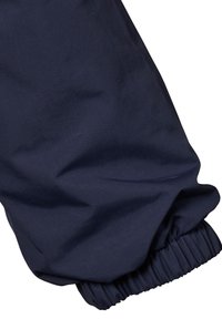 Marint blår tyg med en slät textur och en elastisk manschett. Designen är enkel, med fokus på komfort och funktionalitet.