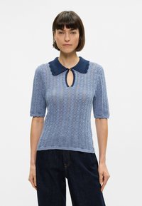 Ανοιχτό μπλε, κοντομάνικος πλεκτός σουέτερ με υφή, κομψό τελείωμα και ναυτικό γιακά. Άνοιγμα κλειδί στον λαιμό, λεπτομέρεια με κουμπί.