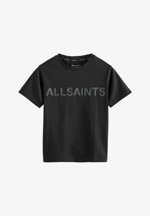Melna kokvilnas T-kreklā ar apaļu kakla izgriezumu un īsām piedurknēm, uz kura priekšpuses ir drukāts "ALLSAINTS" tekstūrētā dizainā.