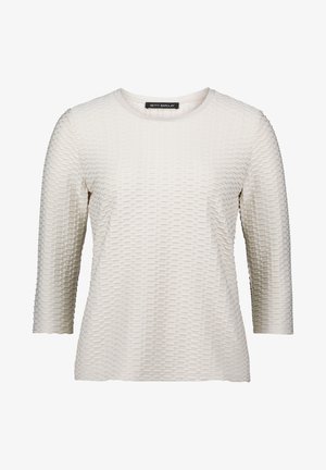 Lichtbeige langemouwen top met een gestructureerd patroon dat lijkt op kleine vierkanten, ronde halslijn en een zachte, gladde stof.