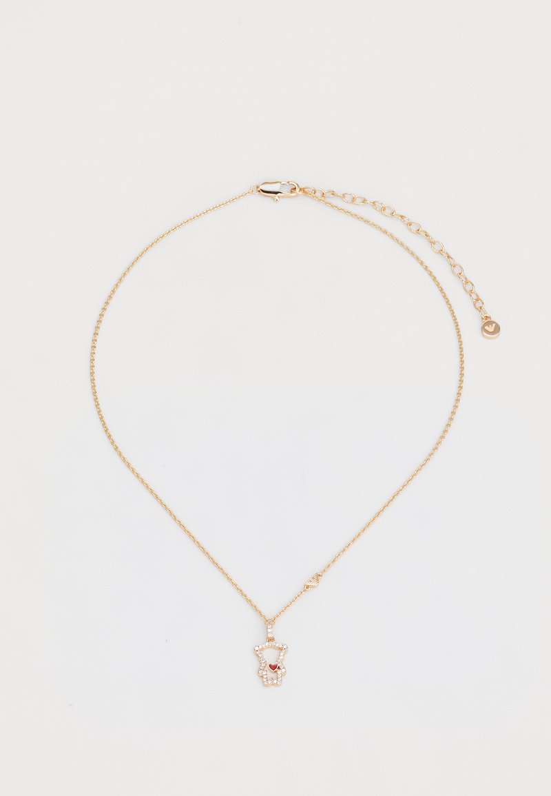 Collar en tono dorado con una delicada cadena, que presenta un colgante de oso de peluche adornado con un corazón rojo y brillantes strass.