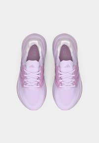 Jasnofioletowe buty sportowe z siateczkową cholewką, teksturowanym wzorem, odblaskowymi akcentami i wyściełanym kołnierzem. Posiadają białe sznurowadła i oznaczenia marki.