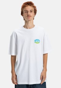 Weiße Baumwoll-T-Shirt in Übergröße mit einem bunten Farbverlauf-Logo auf der Brust. Kurze Ärmel und lockere Passform. Glatte Textur, minimalistisches Design.