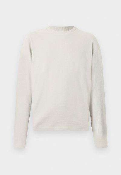 Μπλούζα μακρυμάνικη, σε εκρού χρώμα, ριμπ πλεκτή με στρογγυλή λαιμόκοψη και άνετη εφαρμογή, εμφανίζεται σε λευκό απλό φόντο.