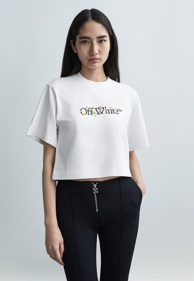 Weißes, kurz geschnittenes T-Shirt mit mehrfarbigem, floralem Off-White-Logo; kombiniert mit schwarzen, enganliegenden Hosen mit silbernem Reißverschlussakzent.