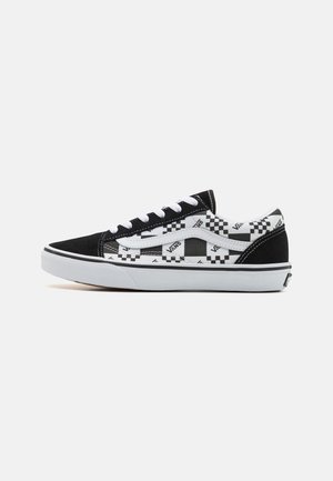 Sneakers Vans in bianco e nero con motivo a scacchi, materiali in suede e tela, suola spessa bianca e accenti neri a contrasto.