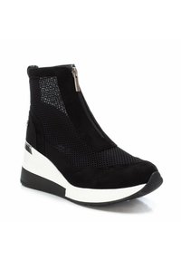 Botines negros con materiales de malla y ante, suela de cuña elegante, cierre de cremallera en la parte delantera y acento blanco en el tacón.