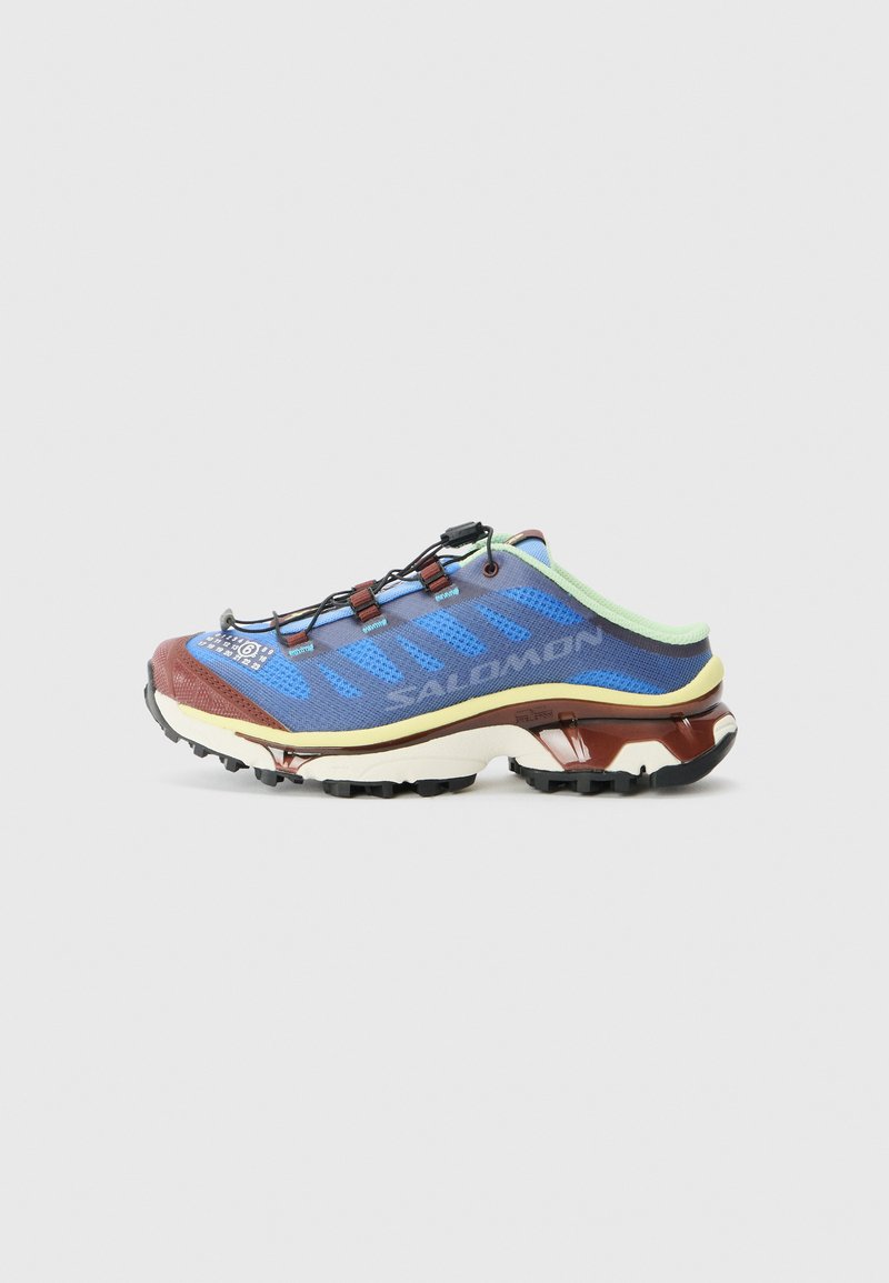Scarpa da trail in mesh blu con accenti marroni e verdi, dotata di suola texturizzata, lacci elastici e punta rinforzata per una maggiore durata.