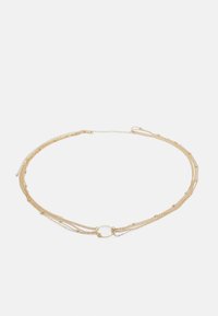 Gold multi-strand necklace featuring layered chains of varying thickness, with a central round connector and small decorative beads.