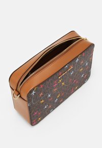 Borsa in pelle marrone e tessuto stampato con chiusura a zip. Presenta design di aerei multicolori su uno sfondo scuro. Dettagli metallici dorati.