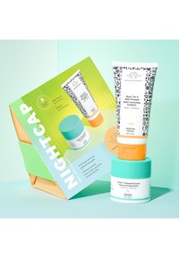 Set includes a green and white boxed kit with two skincare products: a patterned tube and two cream jars with blue and orange accents.