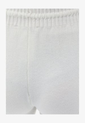 Tessuto a maglia bianco a coste con una cintura elastica. La texture è liscia con sottili righe verticali e dettagli di cucitura discreti.