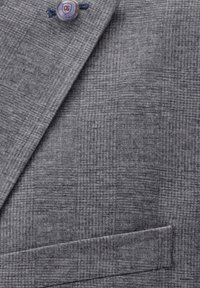 Gray checkered blazer fabric, textured surface, with a prominent logo button and a single pocket detail.