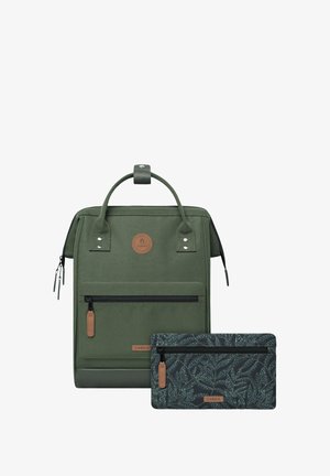 Green fabric backpack with a top handle, front zipper pocket, and a detachable patterned pouch featuring leaf designs in dark tones.