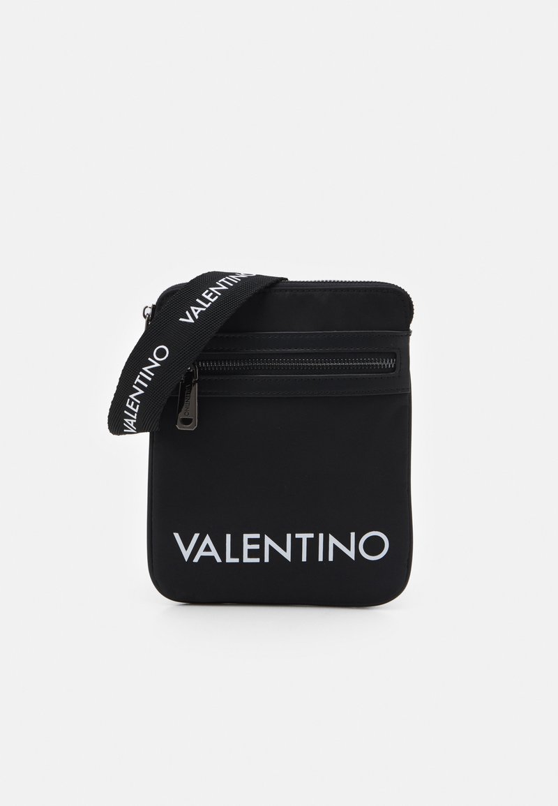 Geantă negre din nylon cu închidere cu fermoar, având o buzunar frontal cu fermoar și o curea marcată "VALENTINO" în alb. Formă rectangulară, textură netedă.