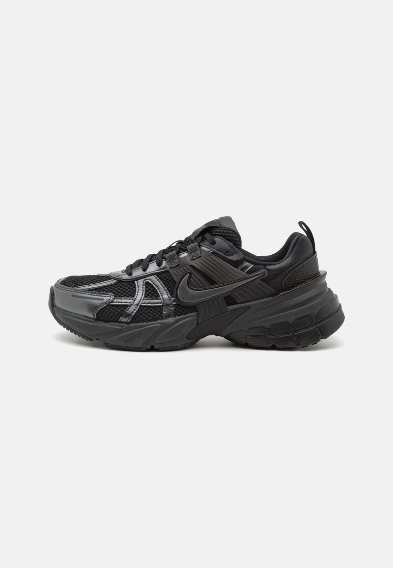 Baskets de sport noires et gris foncé avec mesh et renforts synthétiques, logo Nike sur le côté, semelle amortie et fermeture à lacets.