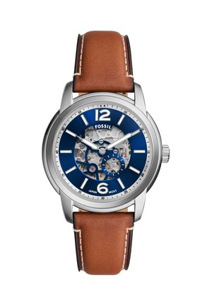 Men’s Fossil wristwatch with brown leather strap, blue dial, silver bezel, visible mechanical gears, and white hour markers.