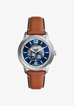 Men’s Fossil wristwatch with brown leather strap, blue dial, silver bezel, visible mechanical gears, and white hour markers.