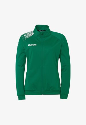 Grøn zip-jakke med ståkrave, lavet af glat stof. Har et geometrisk mønster på venstre skulder og "Kempa" logo i hvid.