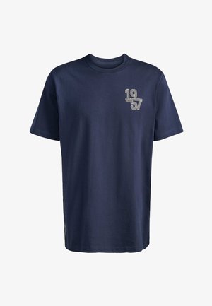 Navy cotton t-shirt with short sleeves, round neck, and printed text "1957" in white on the left chest area. Side vent details.