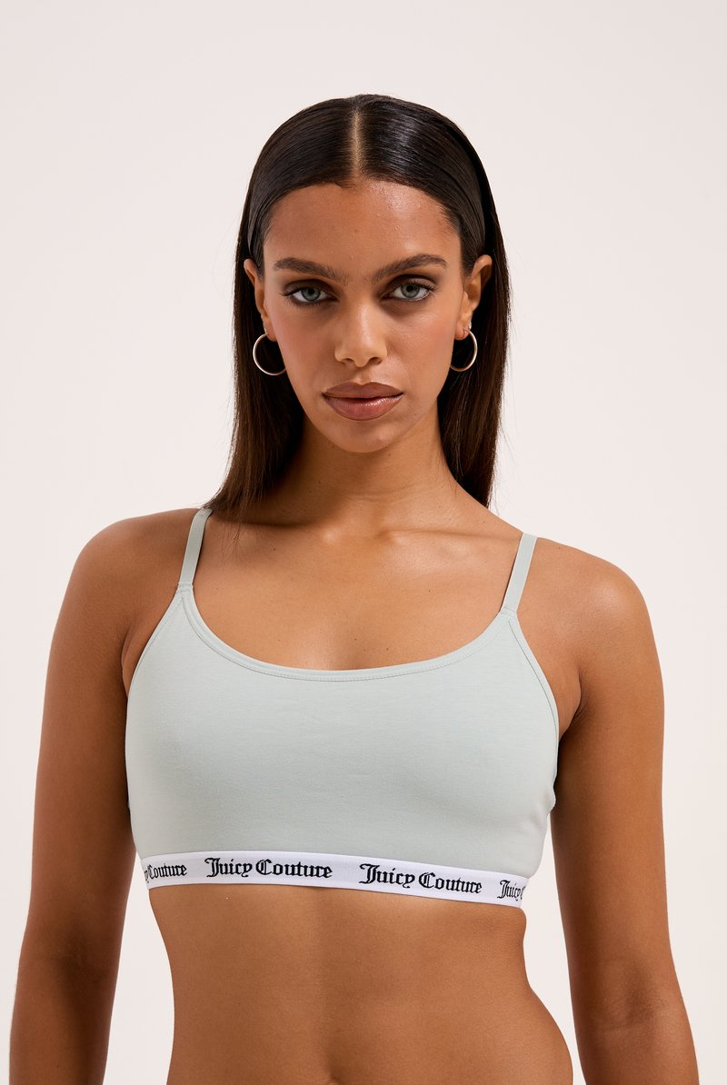 Svetlomodrá bralette vyrobená z mäkkej tkaniny, s tenkými ramienkami a kontrastným bielym pásom s textom "Juicy Couture".